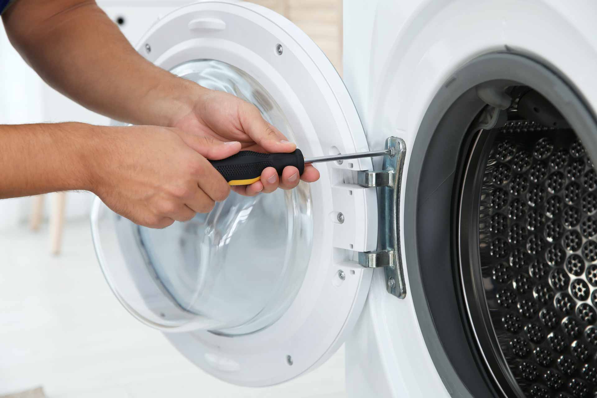 Close-up shot of man fastening door on to dryer