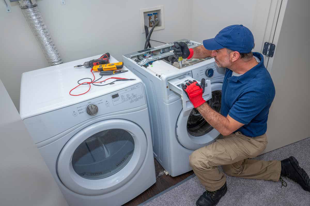 A man repairing the detergent drawer of a washing machine