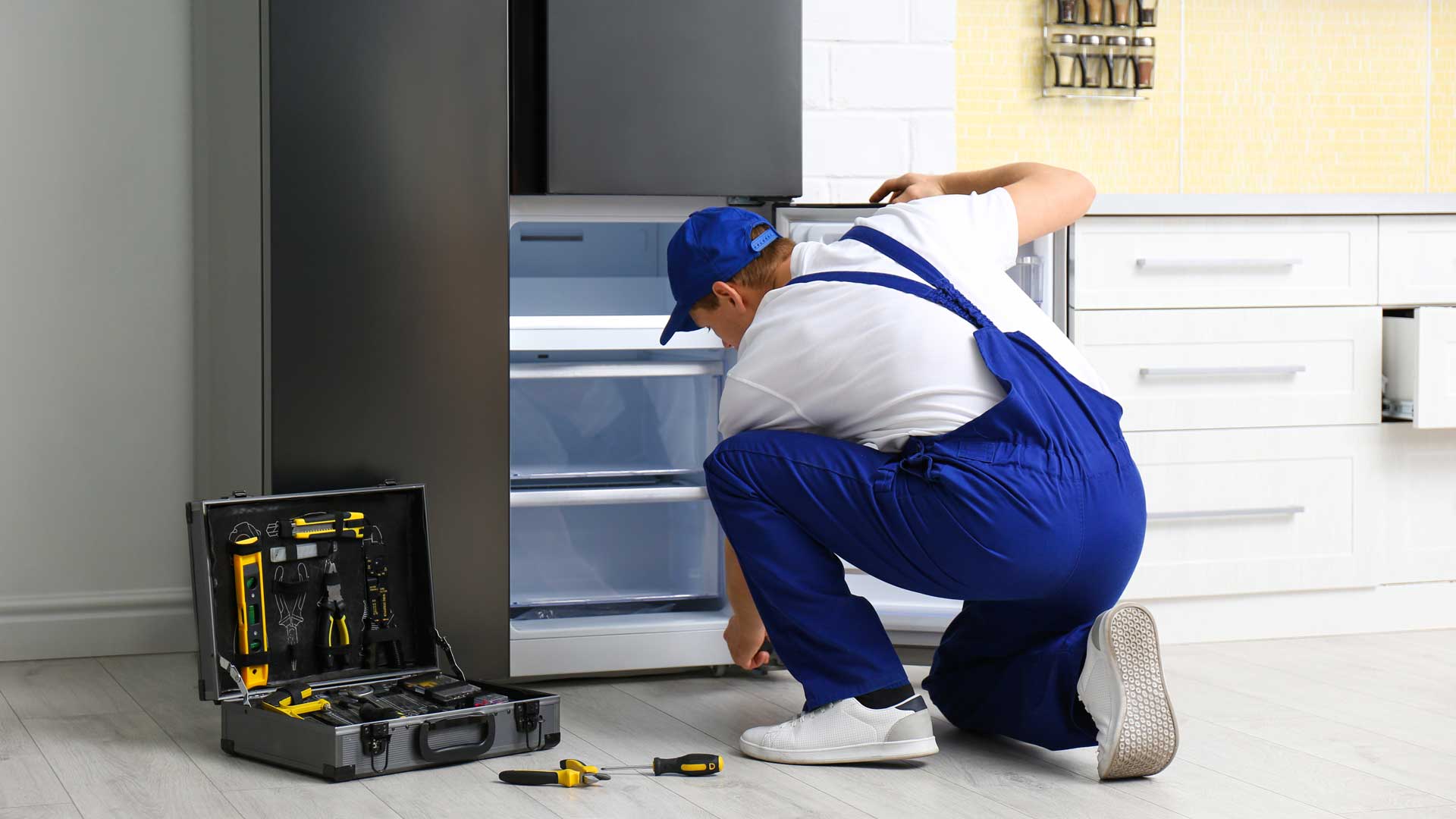 Appliance repair man repairing a refrigerator